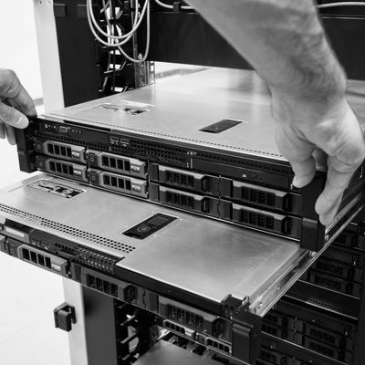 Technician handling rack-mounted servers in a data center.