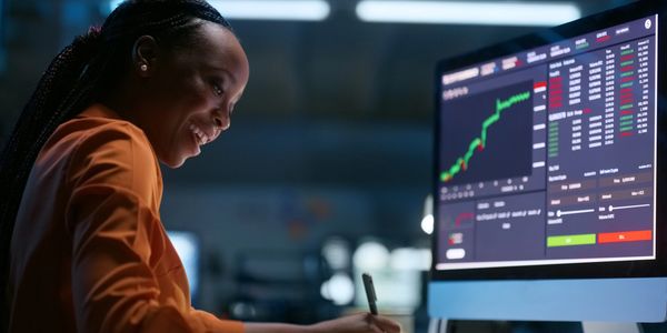 Woman analyzing stock market data on computer.