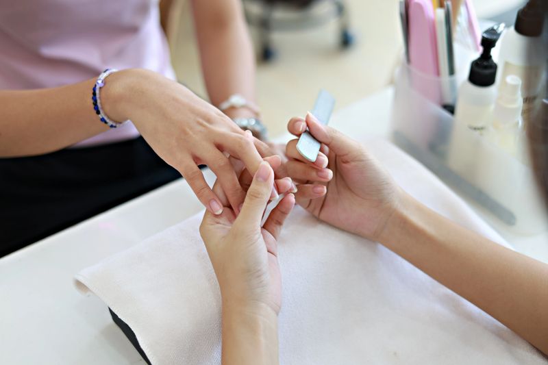 Close-up of beautiful female hands receiving a manicure treatment in a nail salon