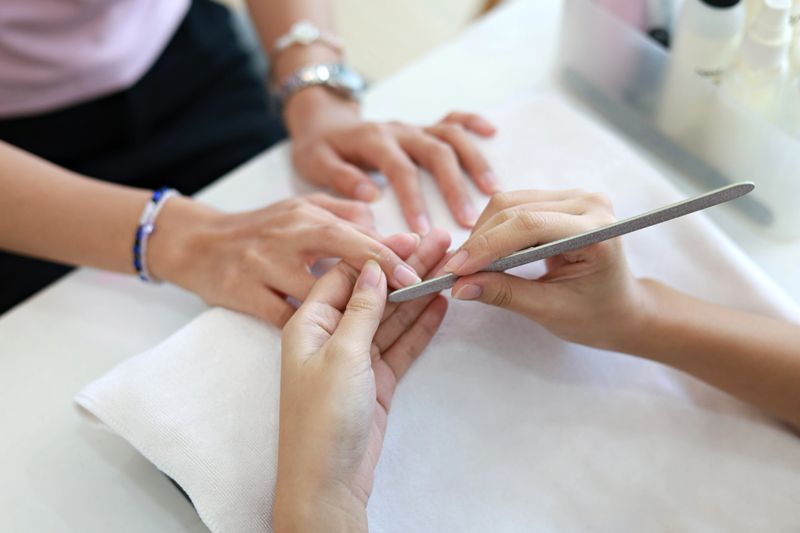 Close-up of beautiful female hands receiving a manicure treatment in a nail salon