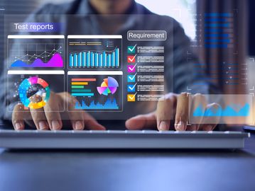 Person analyzing colorful digital test reports and requirements on a transparent screen.