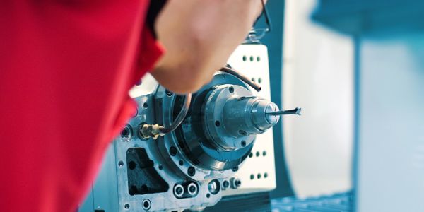 A technician closely inspects a CNC machine tool.