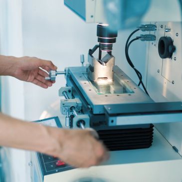 Scientist adjusting a precision microscope in a lab.
