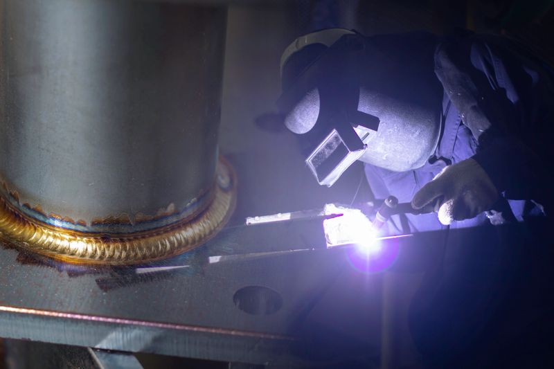 Construction site metal welder. builder wear fireproof gloves for safety at work. Assembling welders welding work in a factory.