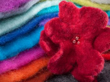 Red felt flower with colorful felt sheets.