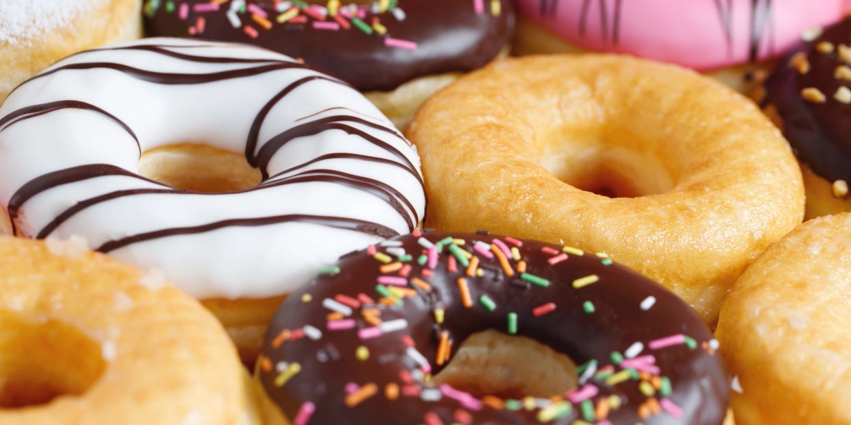 A close-up of assorted colorful donuts with various toppings.