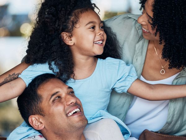 Happy family moment with parents and daughter sharing smiles and laughter.