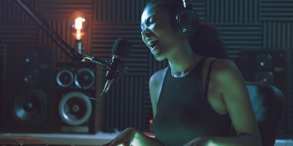 Woman singing passionately in a recording studio.
