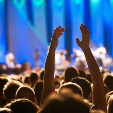 Audience enjoying a live concert with hands raised.