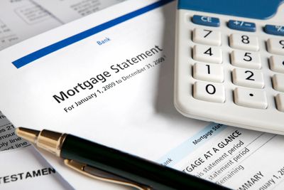 Mortgage payoff concept with hand holding a home model.