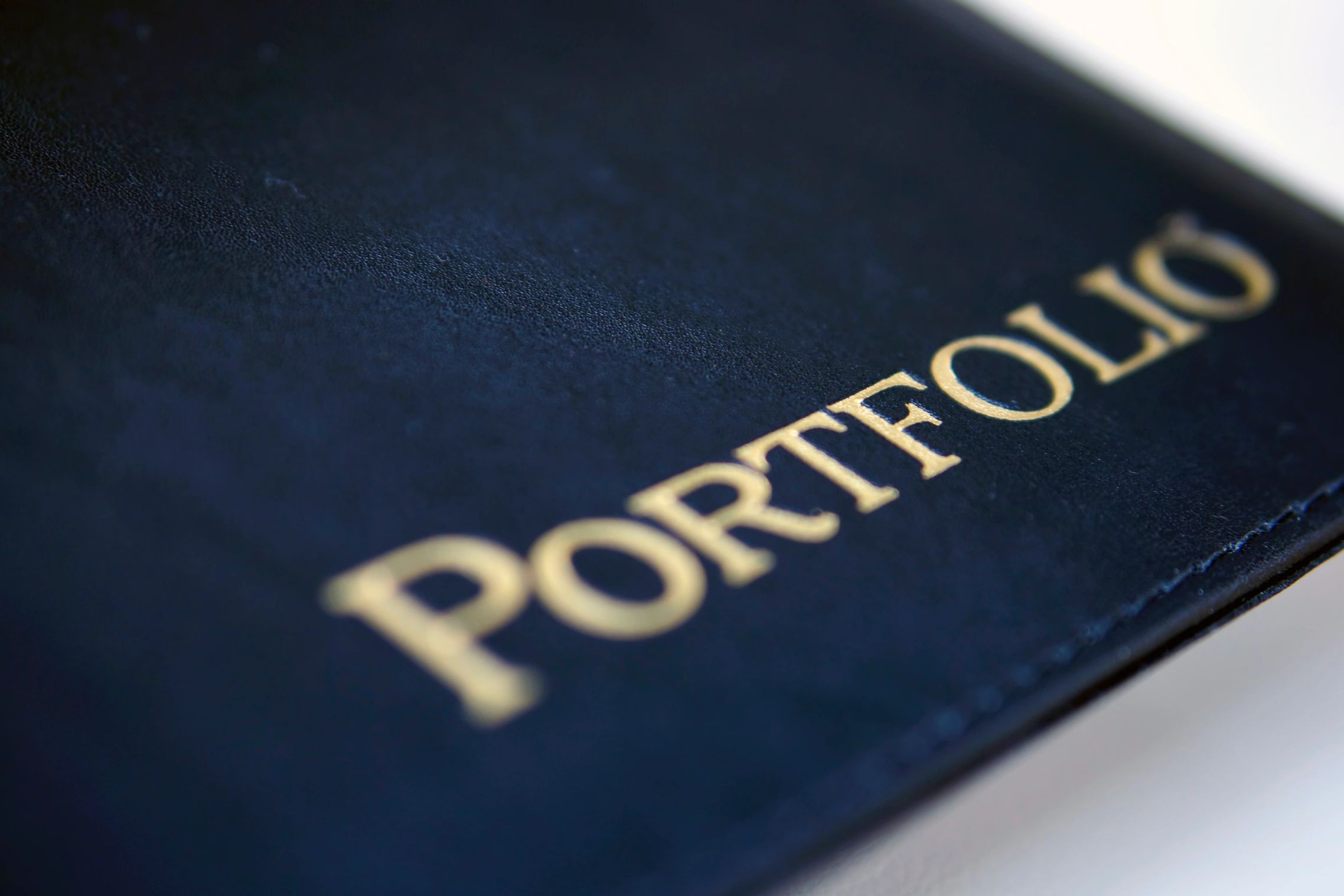 Close-up of a navy blue portfolio with gold lettering.