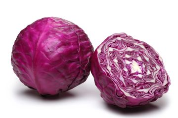 Whole and halved purple cabbage on white background.