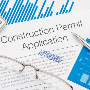 Approved construction permit application with glasses and pen.