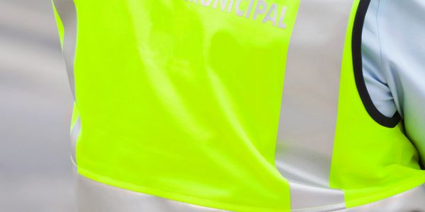 Close-up of a fluorescent yellow safety vest with partial text.