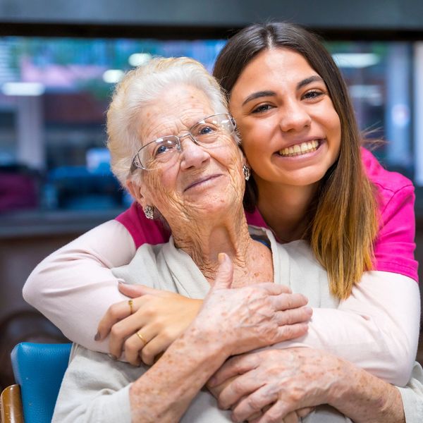 Personal support worker in Kingston, Ontario smiling and embracing an elderly woman, showing compassion, trust, and quality home care