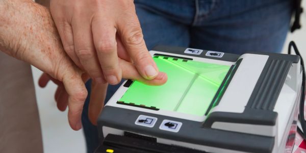 Person scanning fingerprint on biometric device.