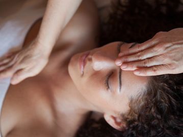 A woman receives a relaxing Reiki energy healing session.