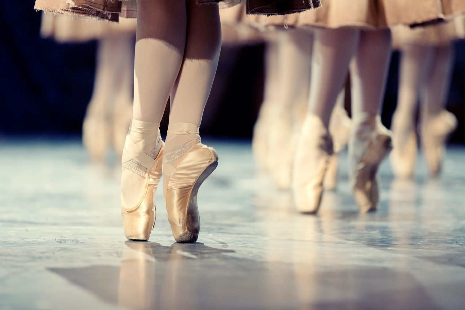 Ballet dancers poised on pointe shoes during a performance.