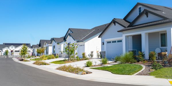 alt="Row of white suburban houses"