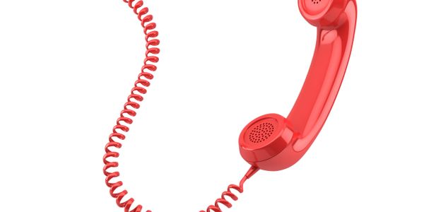 Red telephone handset with coiled cord isolated on white background.