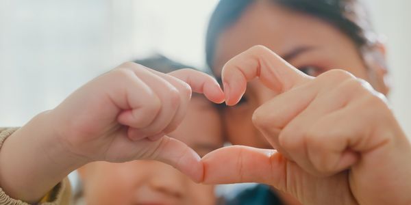 mother daughter with heart hands