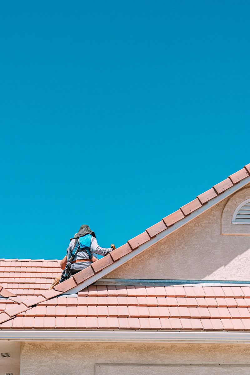 Professional Solar Installation Company Preparing a Clay Roof for Solar Panels on a Suburban Home with Clay Tiles in the Summer