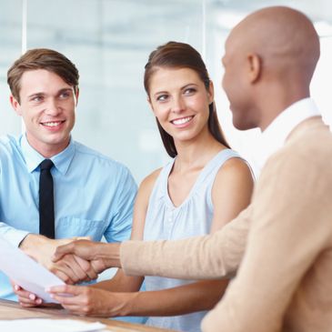 Three professionals shaking hands in a positive business meeting.