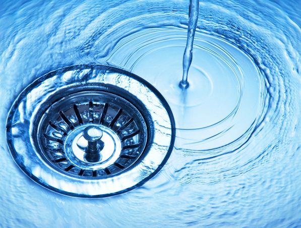 Kitchen sink drain with running water showing proper plumbing flow