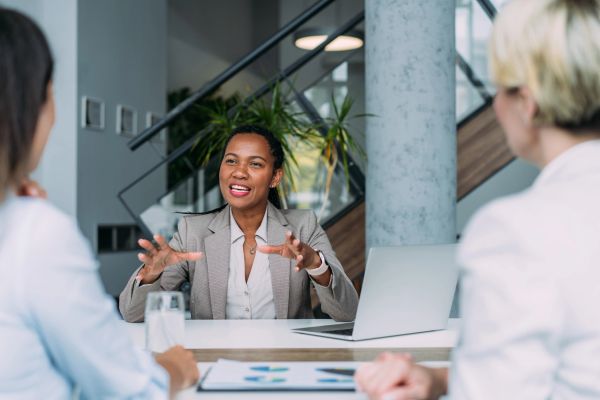 African American business woman discussing a business proposal with two potential female clients