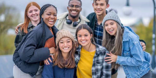 Group of friends smiling happily outdoors.