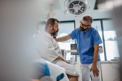 Doctor comforting a patient in a hospital room.