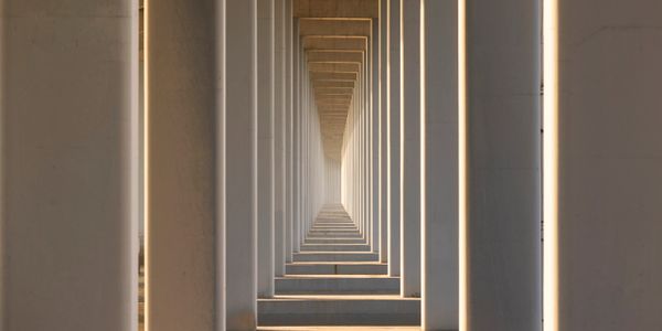 Symmetrical view of sunlit pillars forming a geometric corridor.