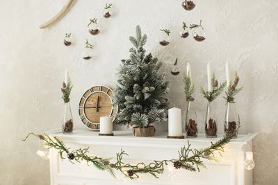 Festive mantle with mini Christmas tree and candles.
