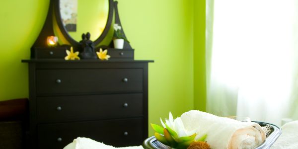 Bright green room with black dresser and towel arrangement.