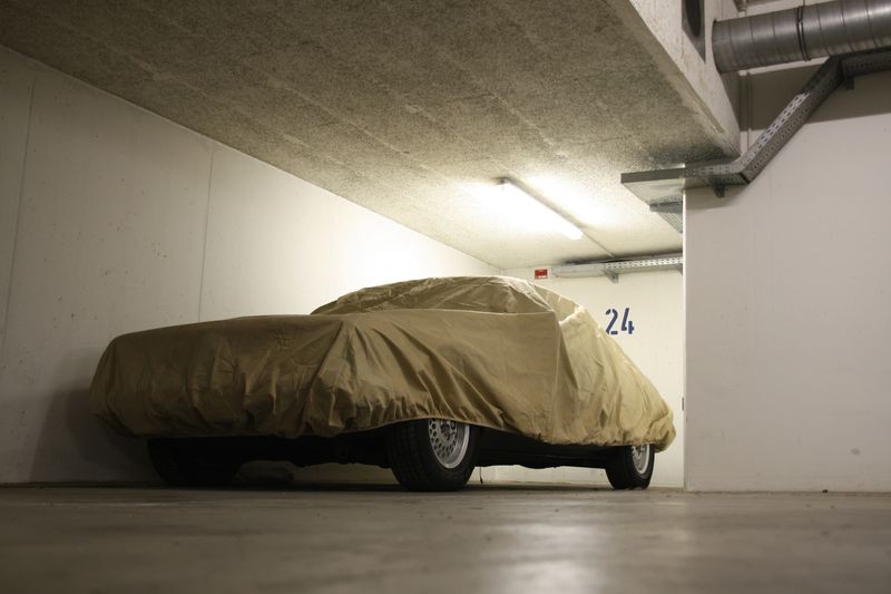 Expensive car in garage with protection cover
