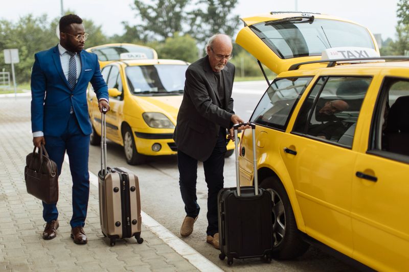A businessman arrives at the airport with a taxi, ready for his flight