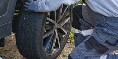 A Man Changing The Tire Of A Car With A Bunch Of Tools