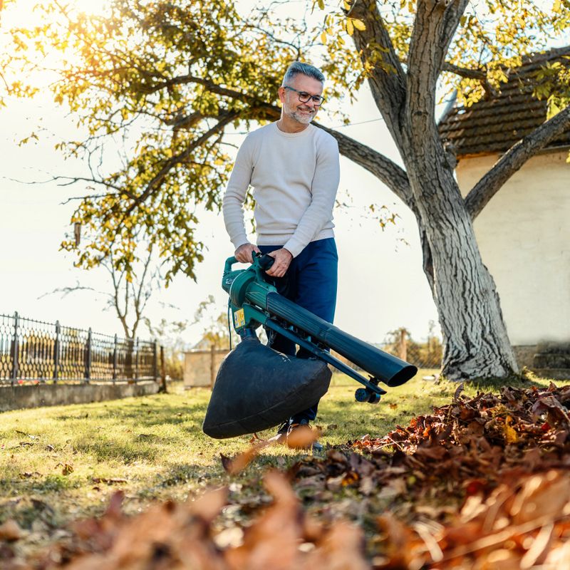 Man blowing leaves during autumn cleaning