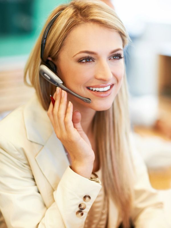Smiling woman with headset working in customer support.