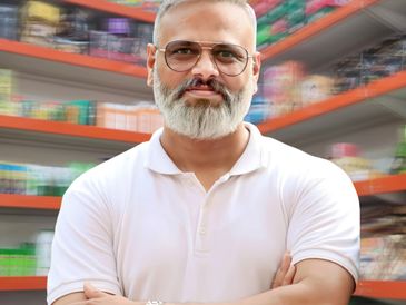 Confident man with gray beard and glasses in a white polo shirt.