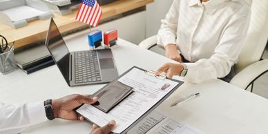 Handing over documents to a legal assistant. An American flag sits on the desk.