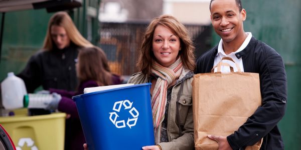 A group of people smiling while recycling at Phoenix Electronics Recycling
