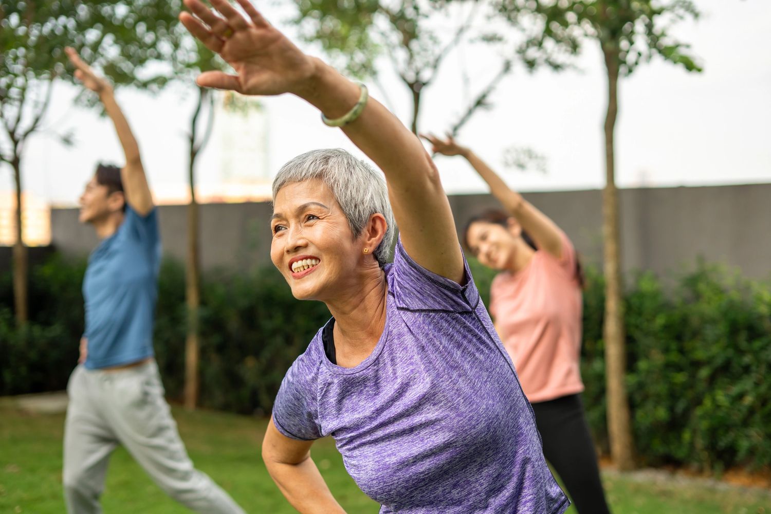 A group of people enjoying outdoor stretching exercises.
