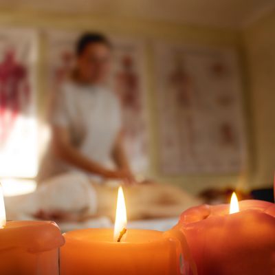 Close-up of lit candles with a blurred person in the background.