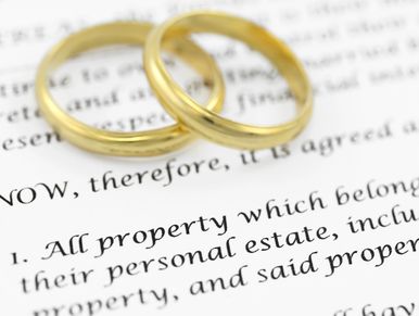 Two gold wedding rings resting on a legal document.