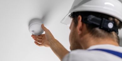 Technician installing a smoke detector.