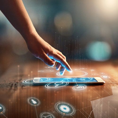 Hand interacting with a smartphone displaying futuristic digital icons.