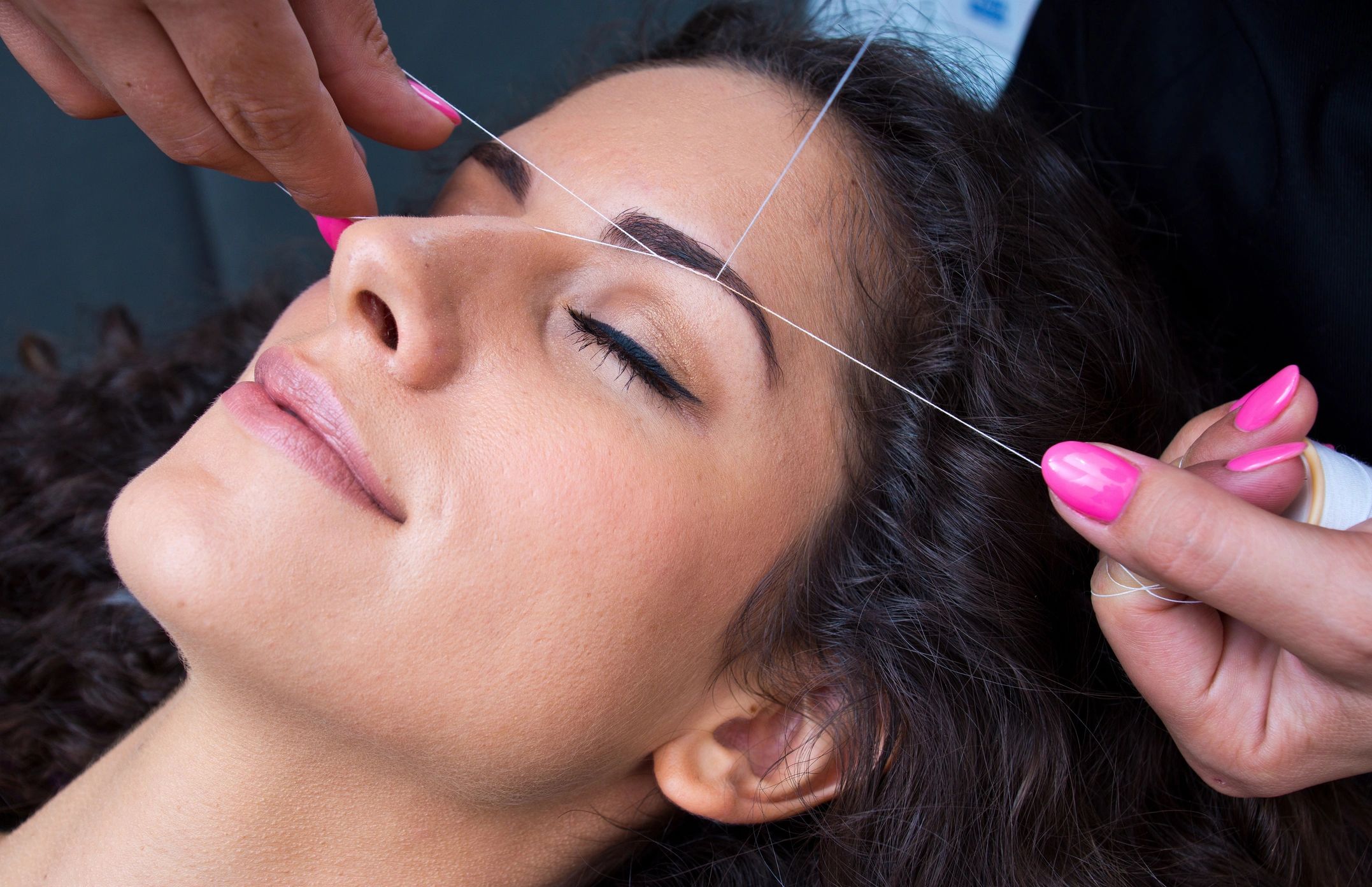 Threading eyebrows to shape and groom.