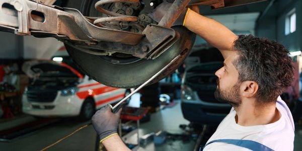 Mechanic repairing car's brake disc in a garage.