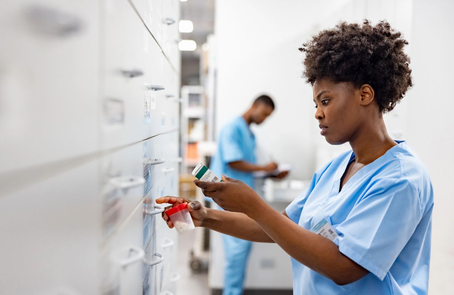 Stack of books next to pencils in a holder and a camera.